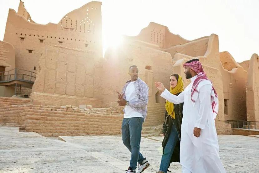 A guide with tourists showing them touristic areas in Saudi Arabia